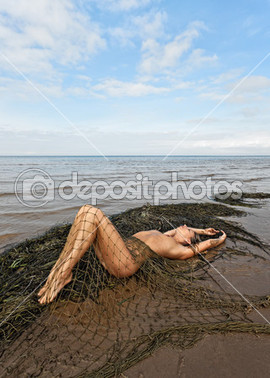 Young nude woman lying on the beach