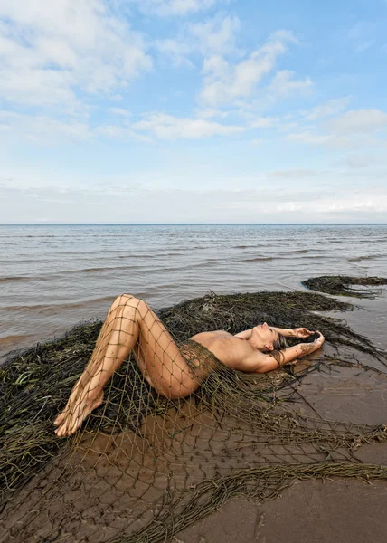 Young nude woman lying on the beach